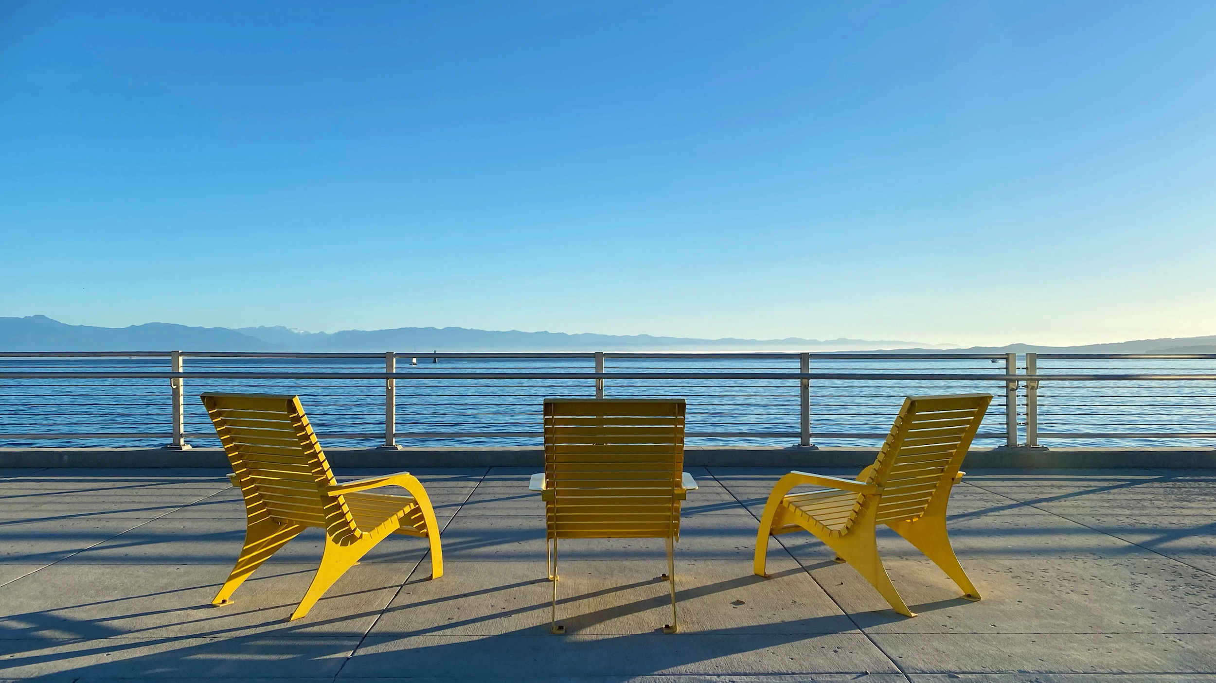 Three yellow chairs overlooking the ocean